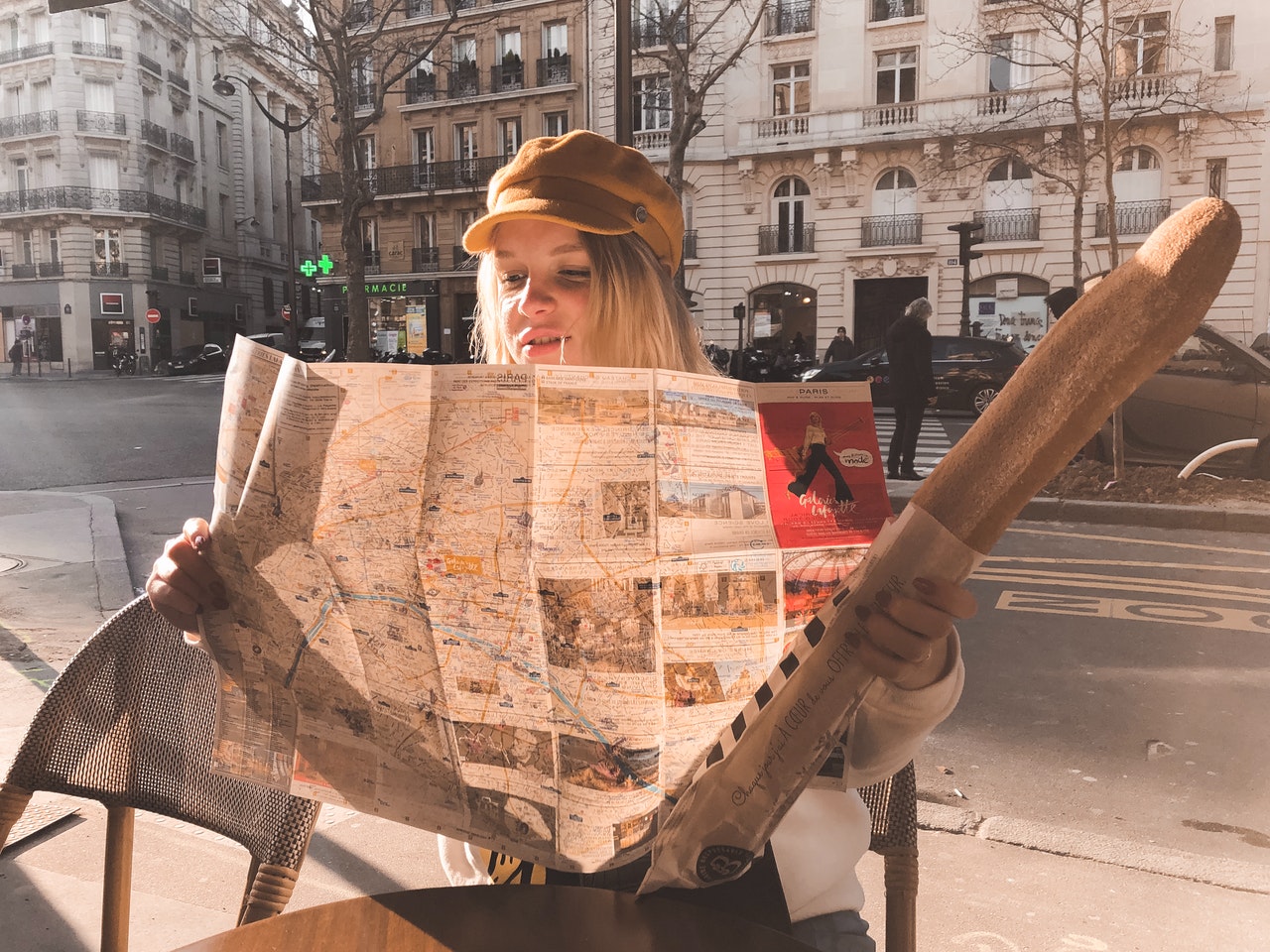 Woman with baguette reading a map itinerary of Romance languages list of countries